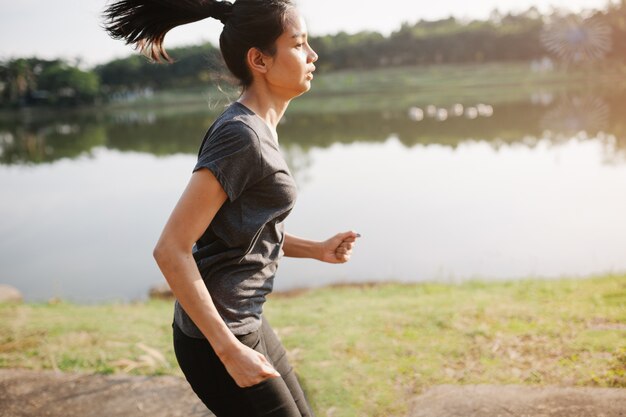 Young woman running next to a lake