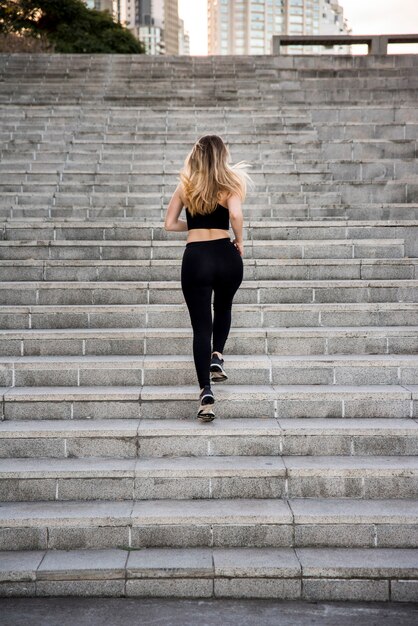 Young woman running outdoors with sportswear