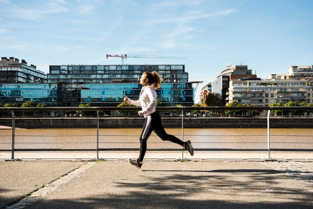 Free photo young woman running outdoors with sportswear