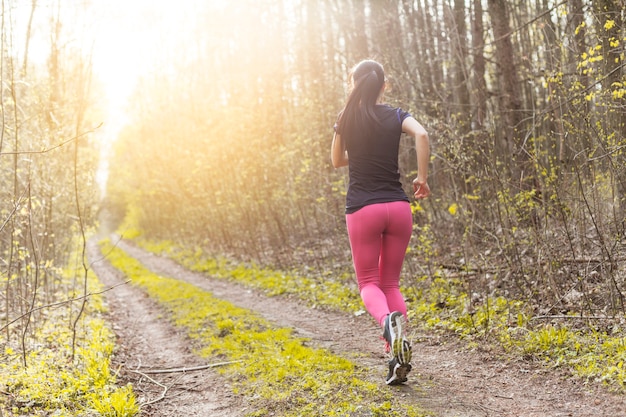 Young woman running through the forest