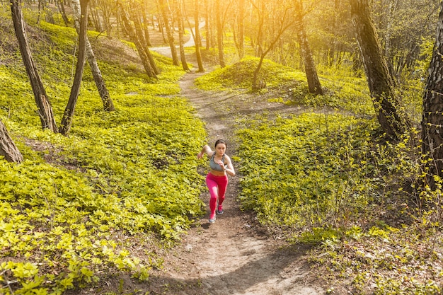 Free photo young woman running through the trees