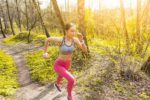 Young woman running through the trees