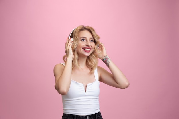 Young woman's portrait on pink studio. Beautiful blonde model