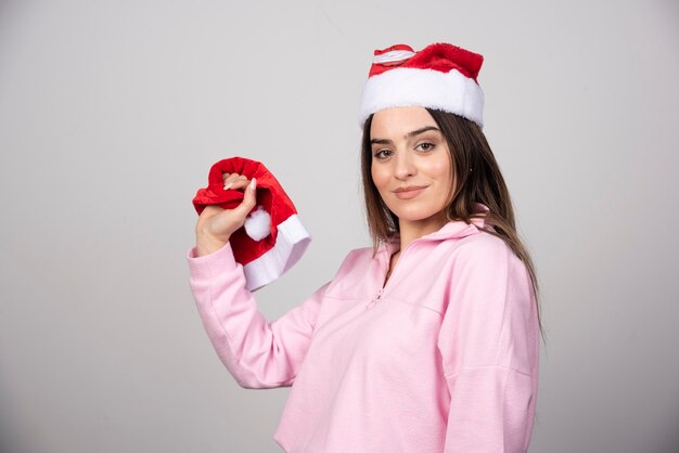 A young woman in Santa Claus red hat holding a hat .