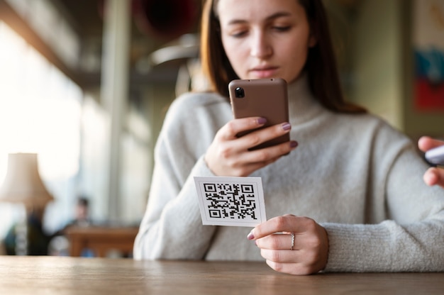 Free Photo young woman scanning qr code