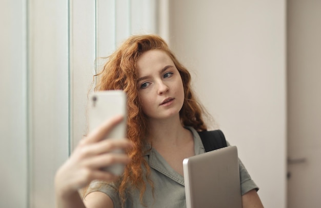 Free photo young woman at school takes a selfie