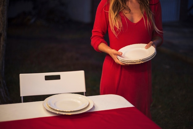 Young woman setting the table for christmas dinner