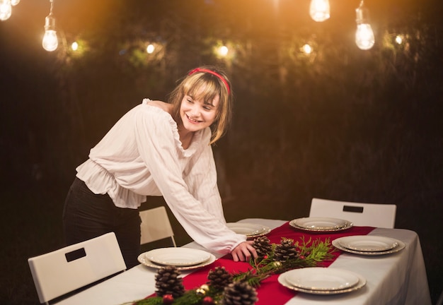 Free Photo young woman setting the table for christmas dinner