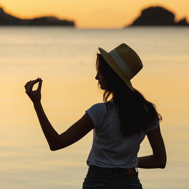 Free photo young woman on the shore of a lake