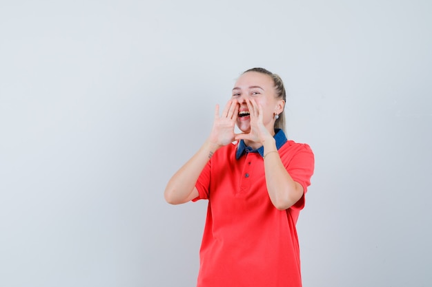 Free photo young woman shouting or announcing something in t-shirt and looking happy