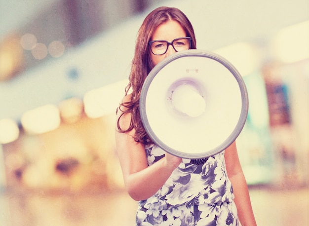 Free photo young woman shouting with megaphone