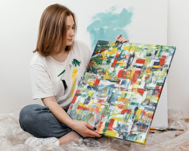 Free photo young woman showing her painting