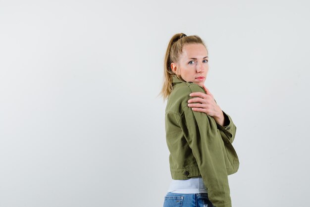 Young woman showing her shoulder on white background