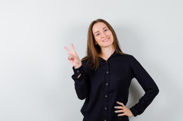 Young woman showing peace gesture