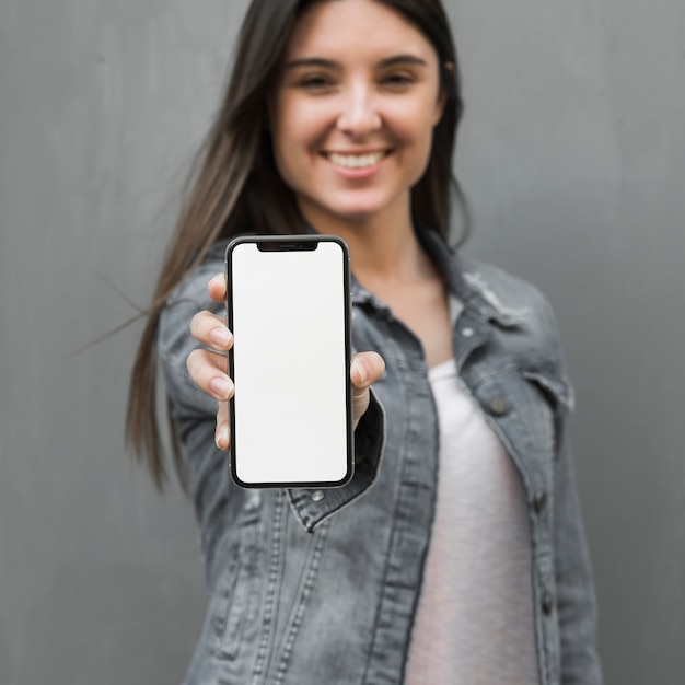 Young woman showing smartphone in hand 