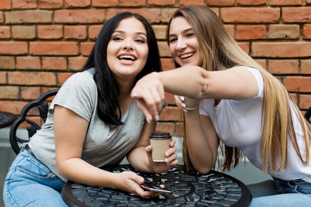 Young woman showing something to her friend