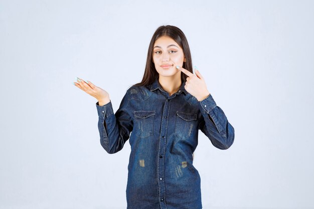 Young woman showing something in her open hand