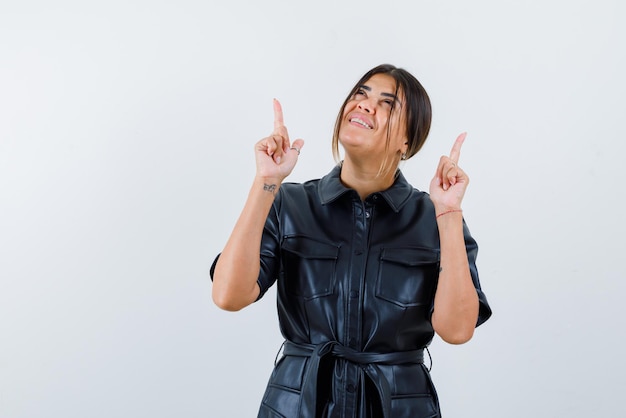 Young woman showing the top with fingers on white background