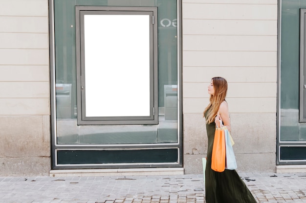 Free photo young woman shpping in the street and template