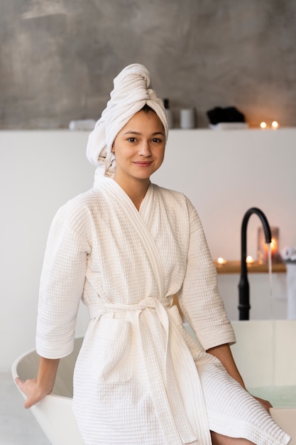 Free photo young woman sitting by the bathtub before taking a bath