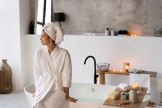 Young woman sitting by the bathtub before taking a bath