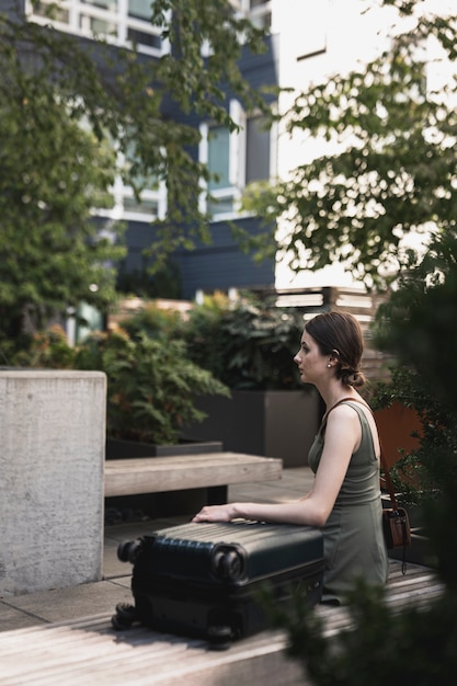 Free photo young woman sitting on cement seat