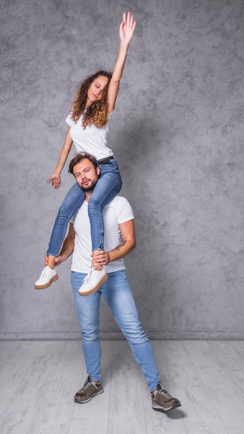 Free photo young woman sitting on man shoulders