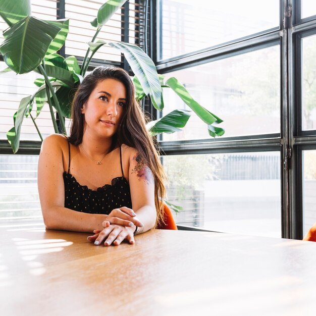 Young woman sitting near the window at table