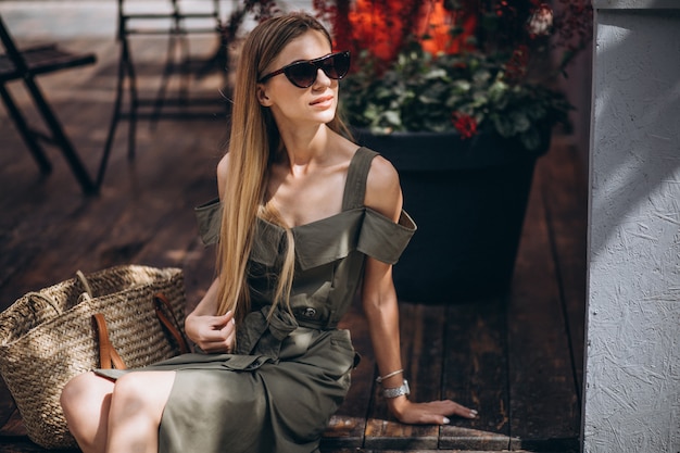 Free photo young woman sitting outside the cafe