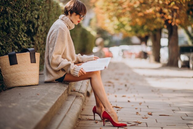 Young woman sitting in park and reading