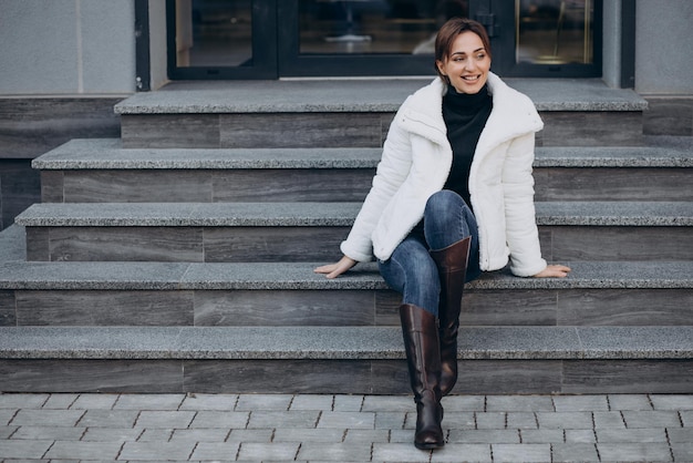 Young woman sitting on stairs outdoors