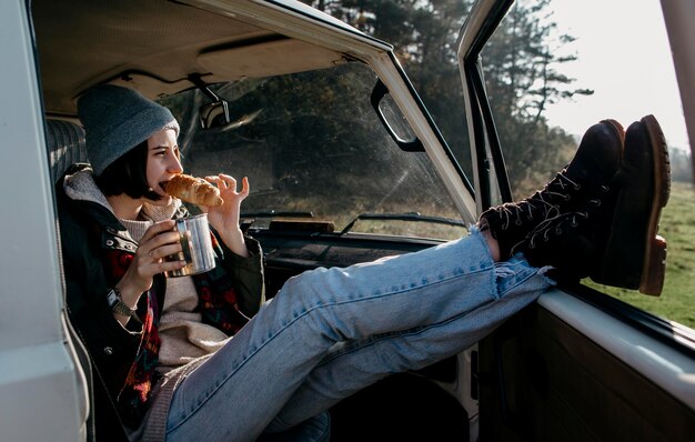 Young woman sitting in a van with her legs out