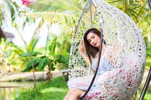 Free photo young woman sitting in white swing