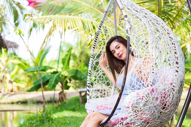 Free Photo young woman sitting in white swing