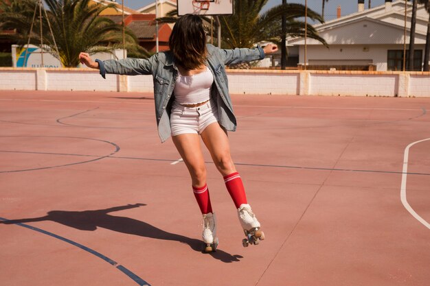 Young woman skating on outdoor court