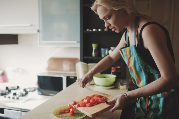 Young woman slicing tomatoes