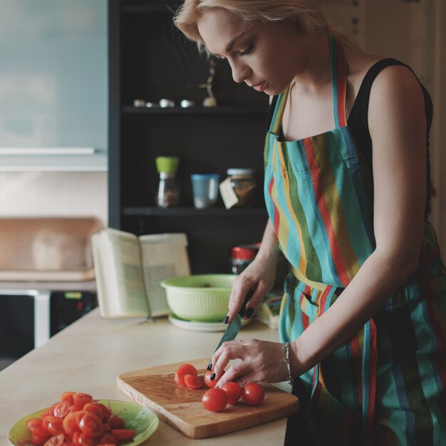 Young woman slicing tomatoes