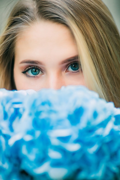 Free photo young woman smells the buquet of hydragea walking in the summer garden