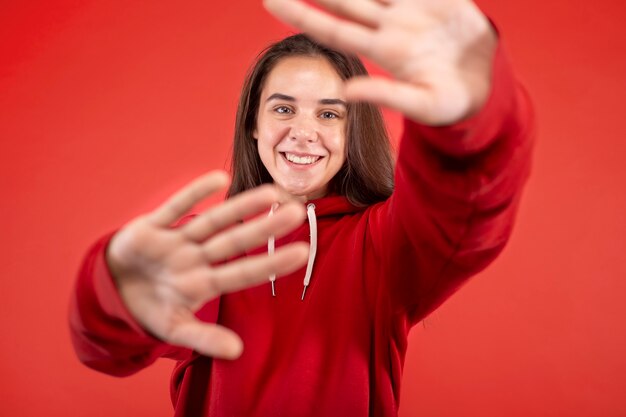 Young woman smiling isolated on red