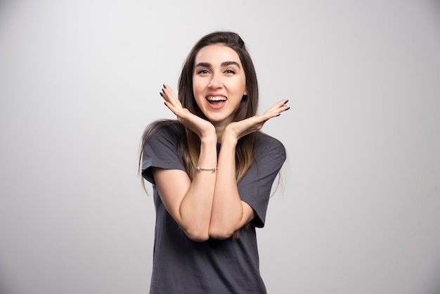 Young woman smiling and posing over a gray background.