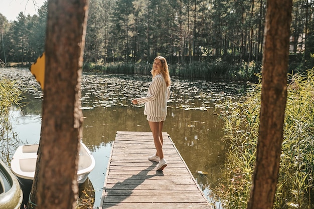 Free photo young woman spending a day in the park near the water