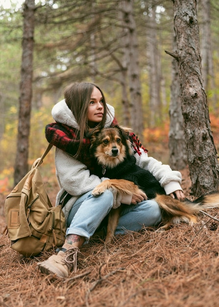 Free Photo young woman spending time together with her dog in a forest