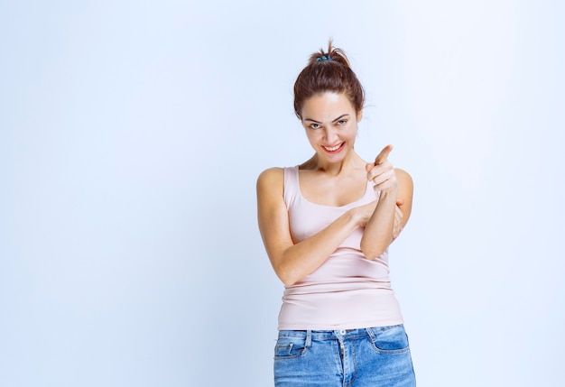 Free photo young woman in sport shirt noticing and showing someone ahead