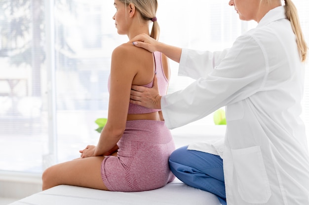 Free photo young woman in sportswear practicing an exercise in a physiotherapy session