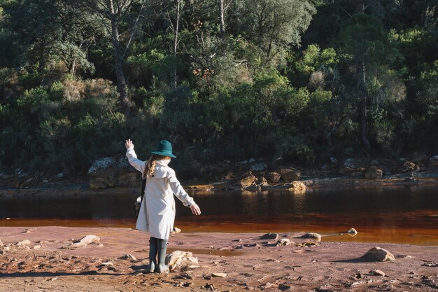 Young woman standing at dirty river