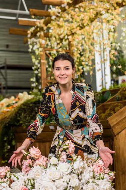 Free photo young woman standing near rose flowers