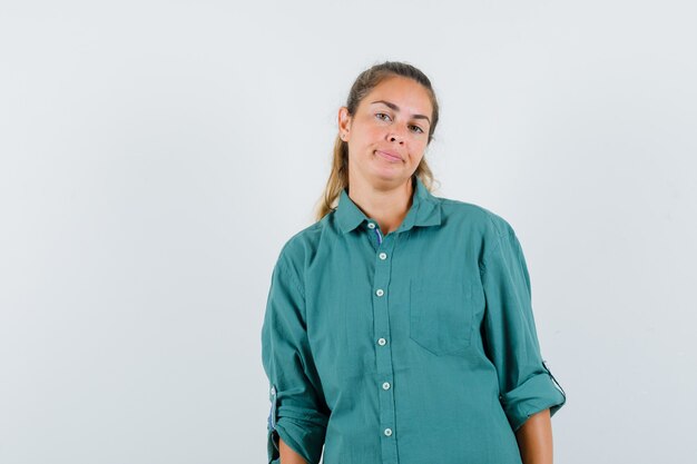 Young woman standing straight and posing at front in green blouse and looking cute