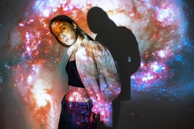 Young woman standing in universe texture projection