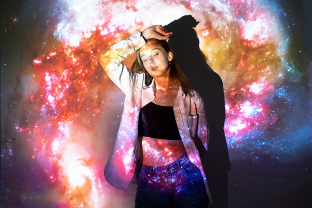 Young woman standing in universe texture projection