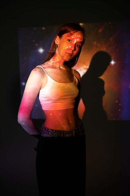 Young woman standing in universe texture projection